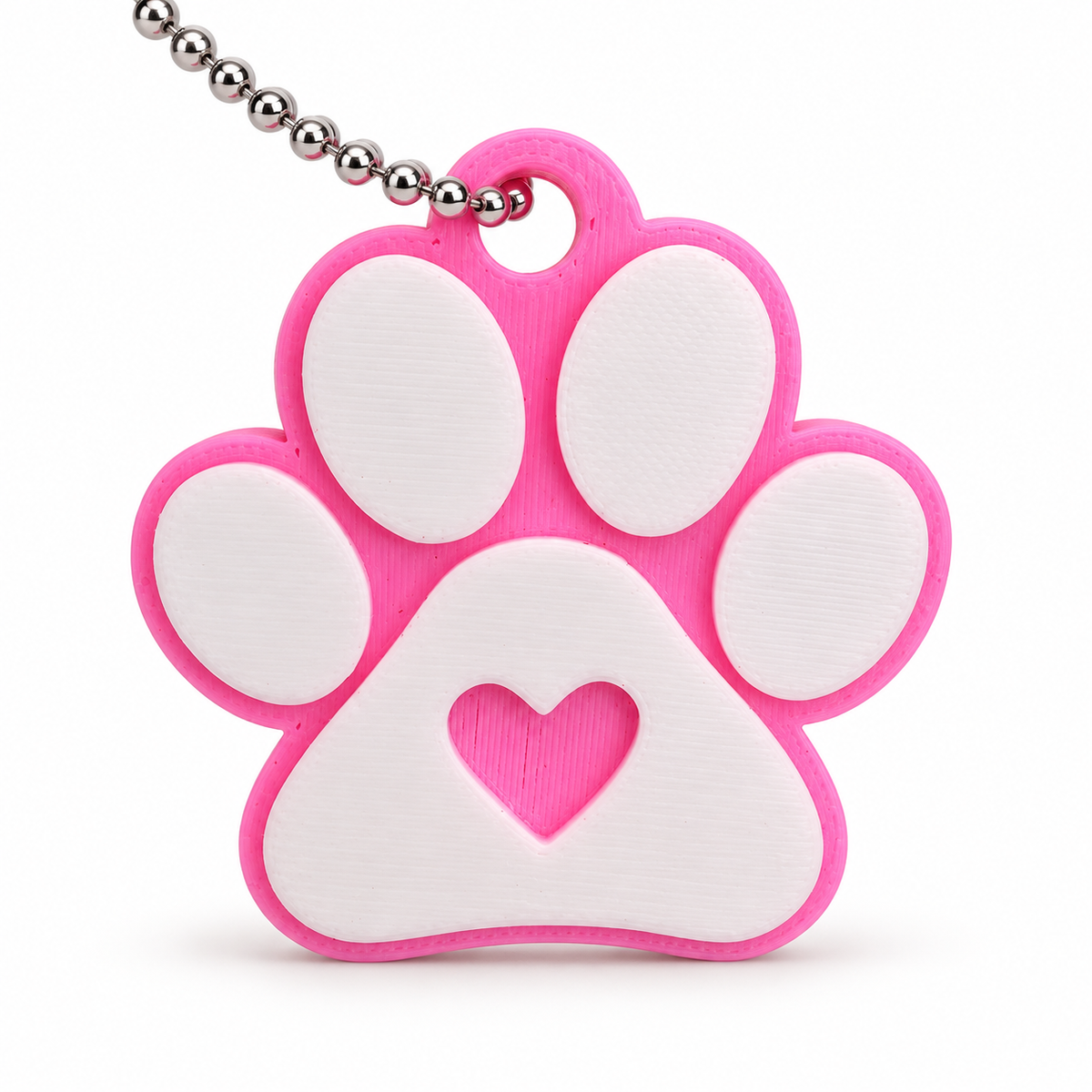 Close view of pink paw print keychain with white pads and heart