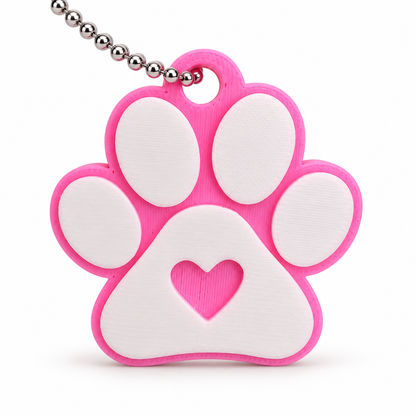 Close view of pink paw print keychain with white pads and heart